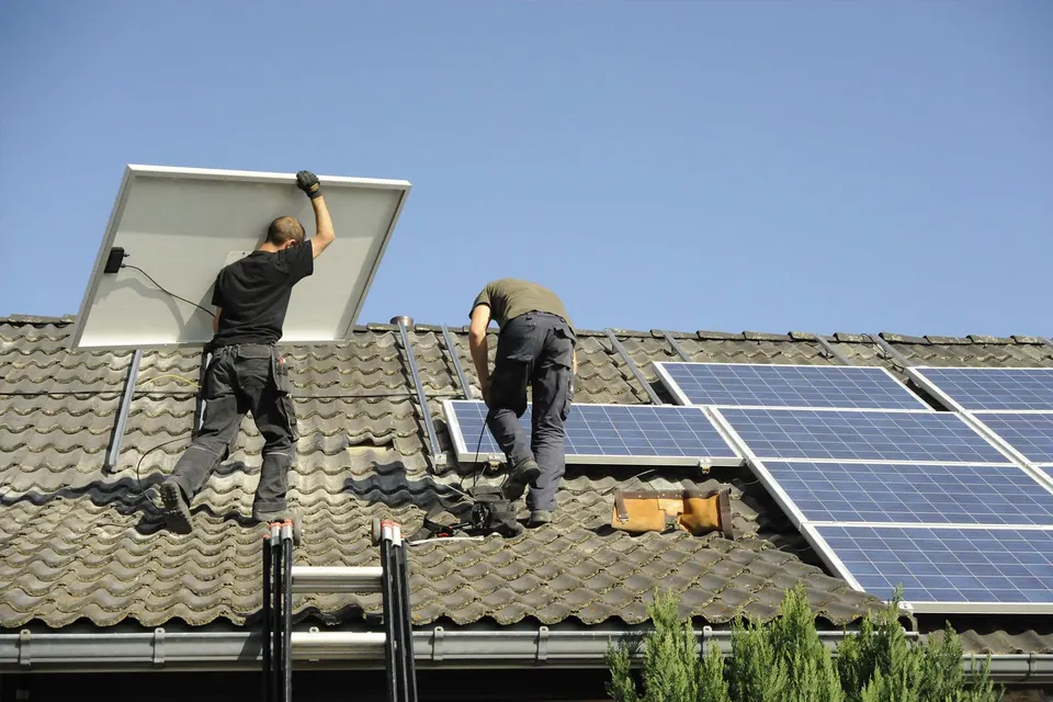 Monteure installieren Solarmodule auf einem Ziegeldach